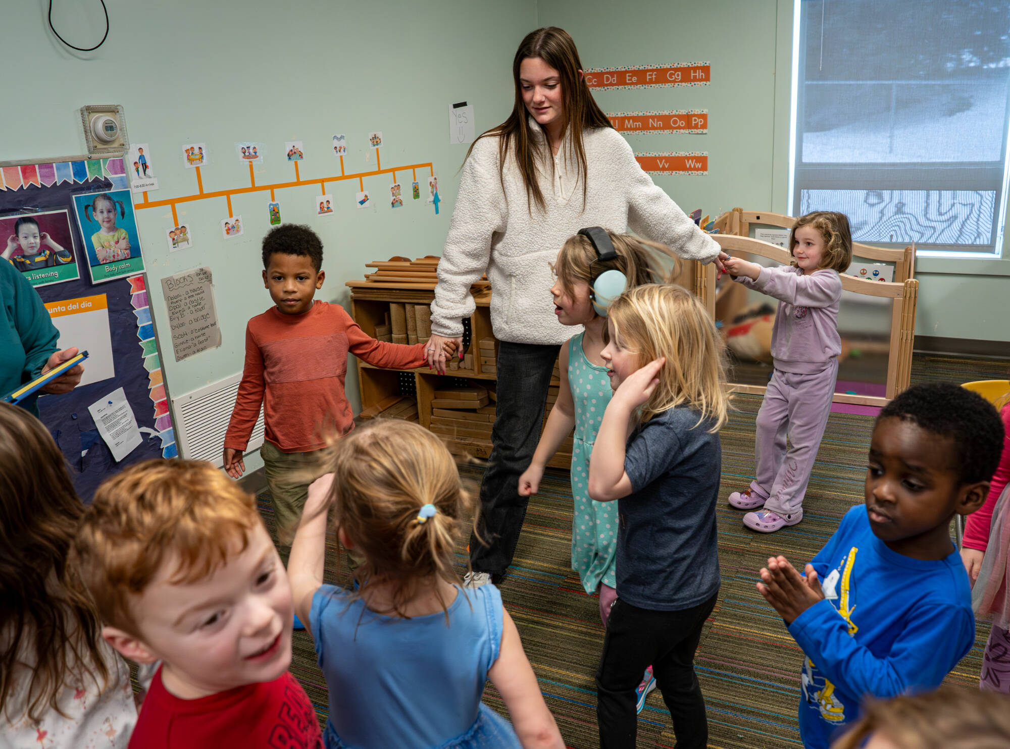 Bailey LoFiego plays with preschool 3 students while working at the Children’s Enrichment Center on February 11. LoFiego, who attended the center as a toddler, is an allied health science major who is minoring in business. (Photo releases on file)